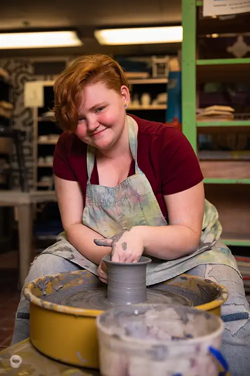 person sitting at pottery wheel