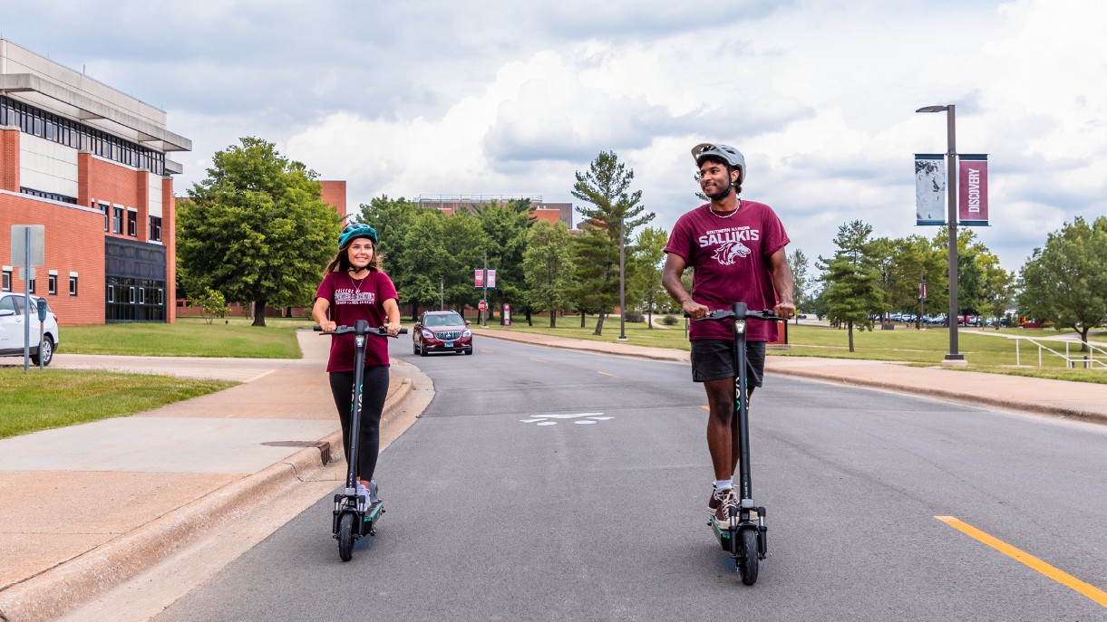 students riding the scooters