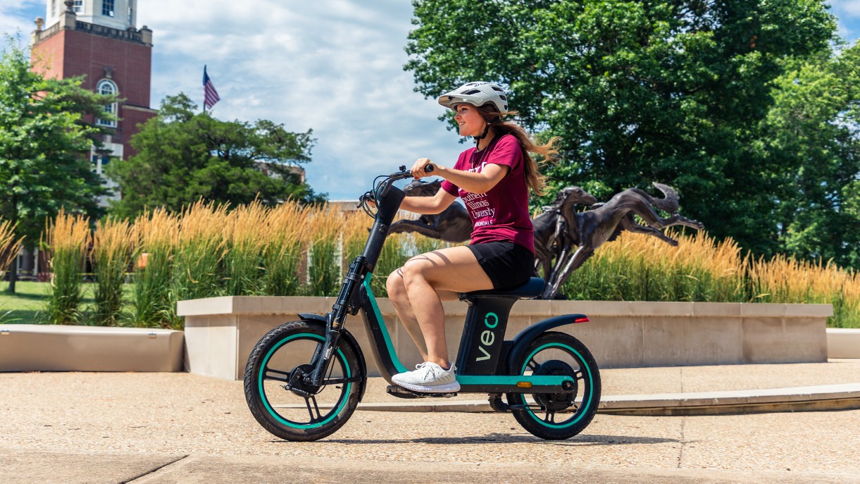 a student rides the sit-down Veo scooter